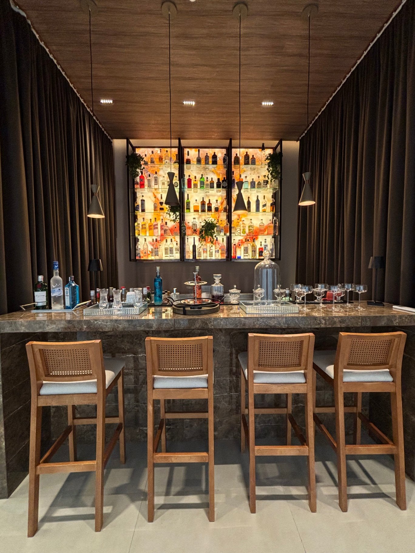Bar principal da Reserva Connect com prateleira iluminada de bebidas