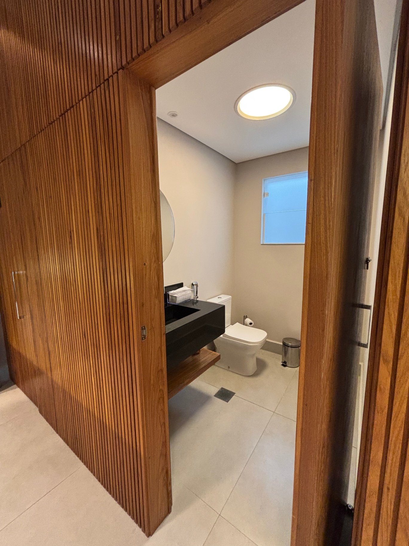 Lavabo com painel ripado de madeira e cuba preta