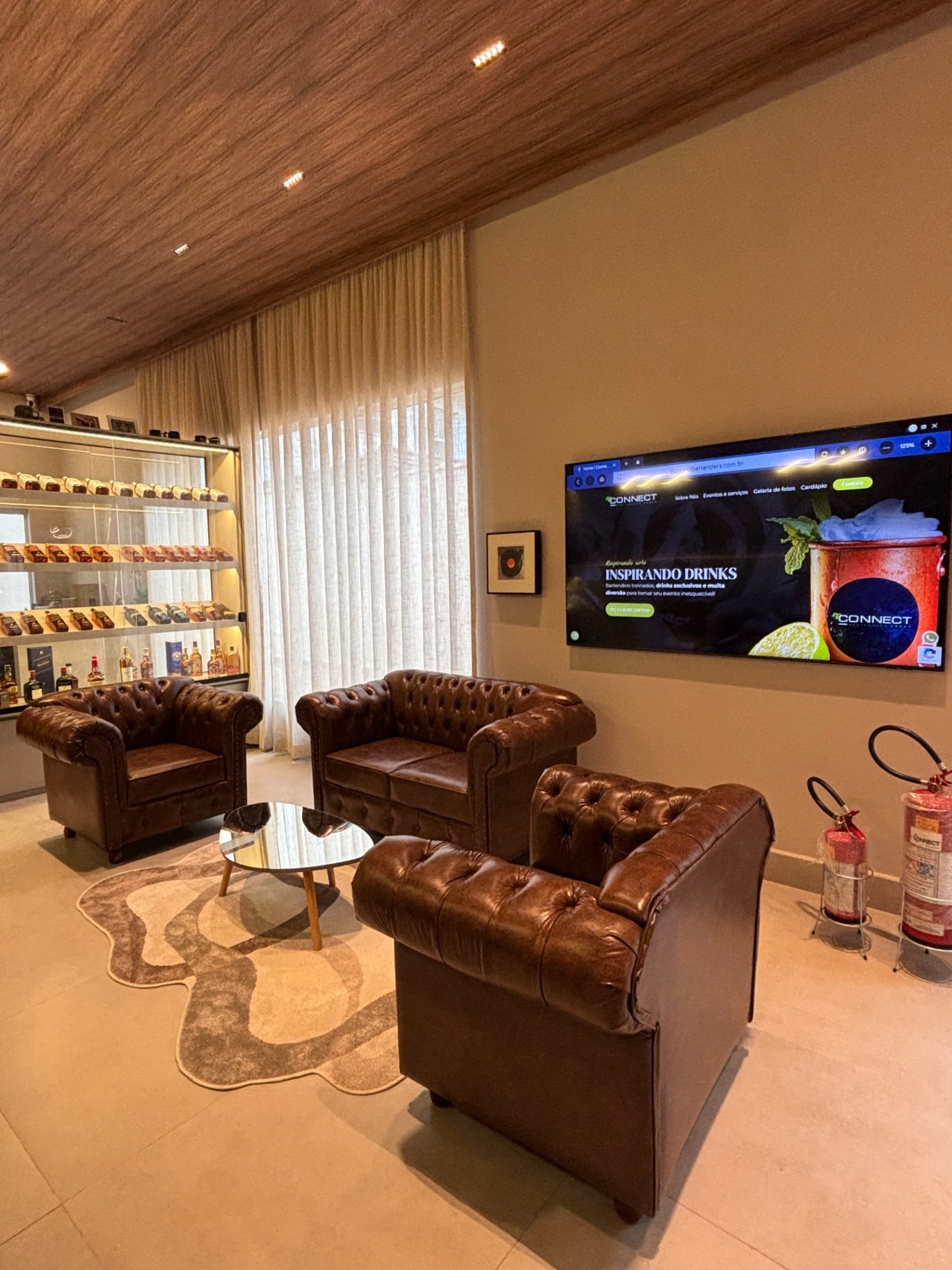 Sala com sofás Chesterfield de couro e adega de whiskys
