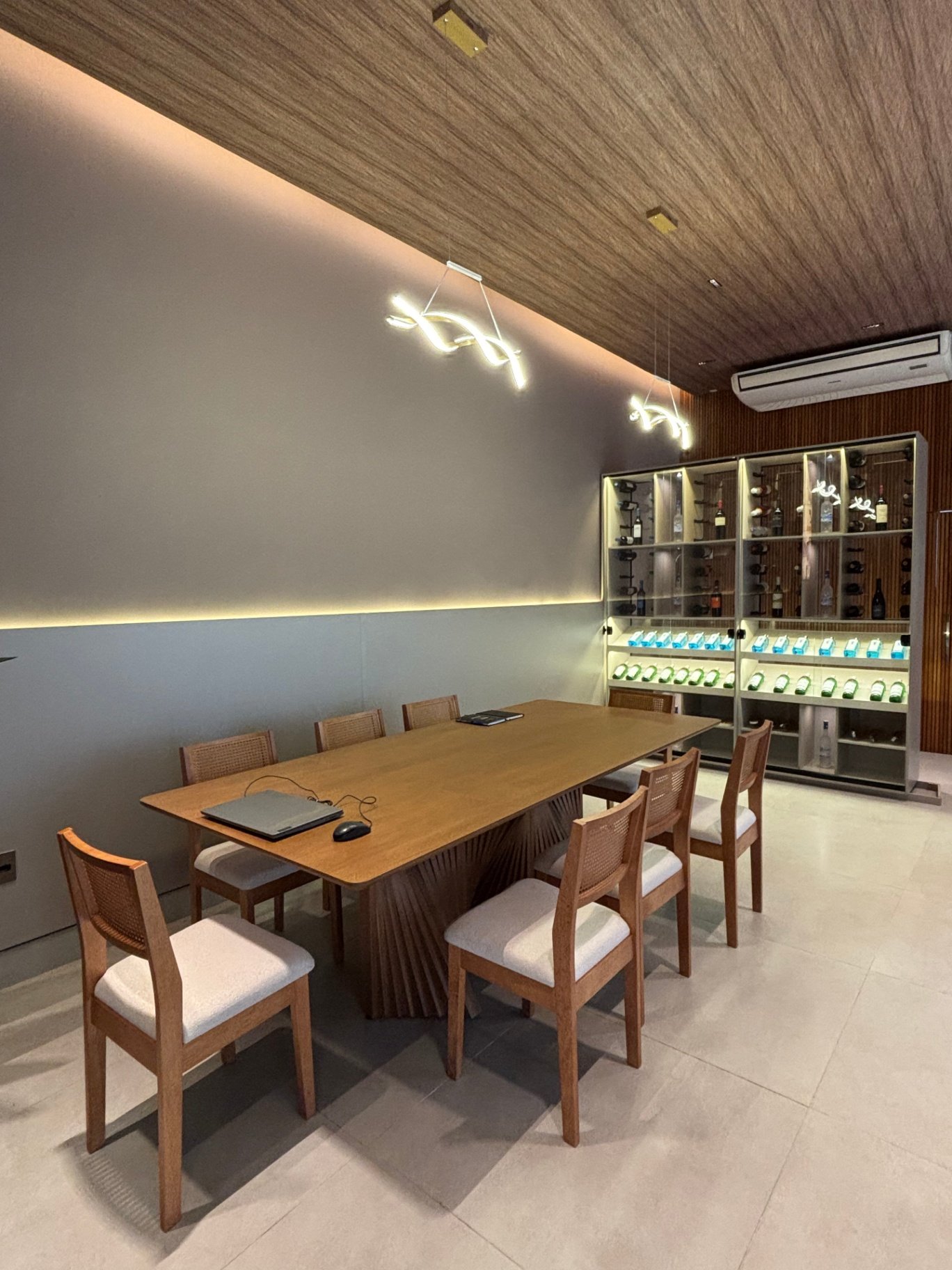 Sala de jantar com mesa de madeira e adega ao fundo
