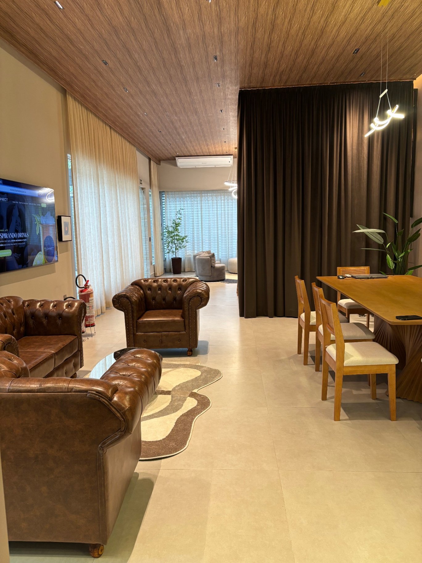 Ambiente com poltronas de couro marrom e mesa de jantar