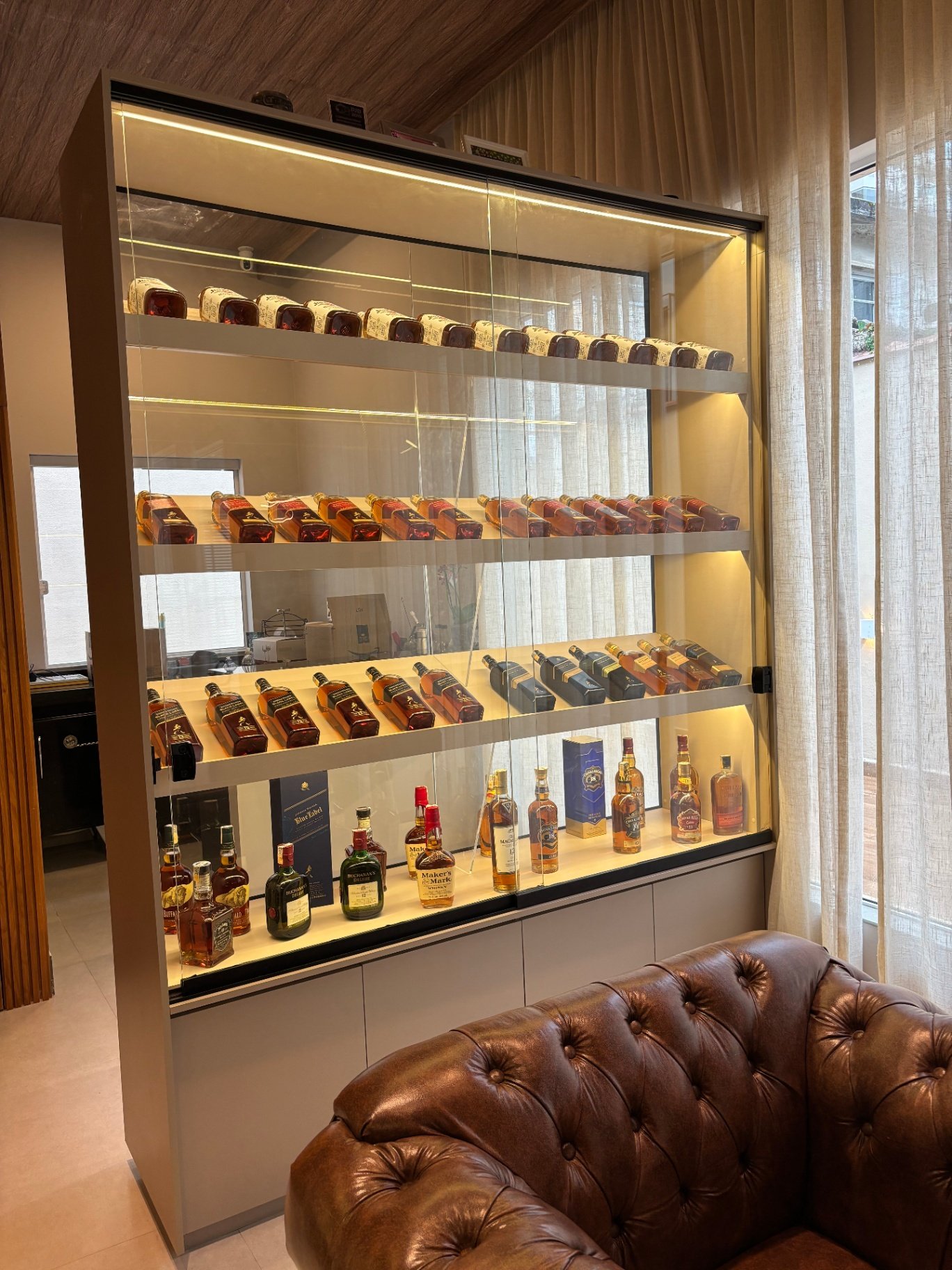 Vitrine iluminada com coleção de whiskys premium